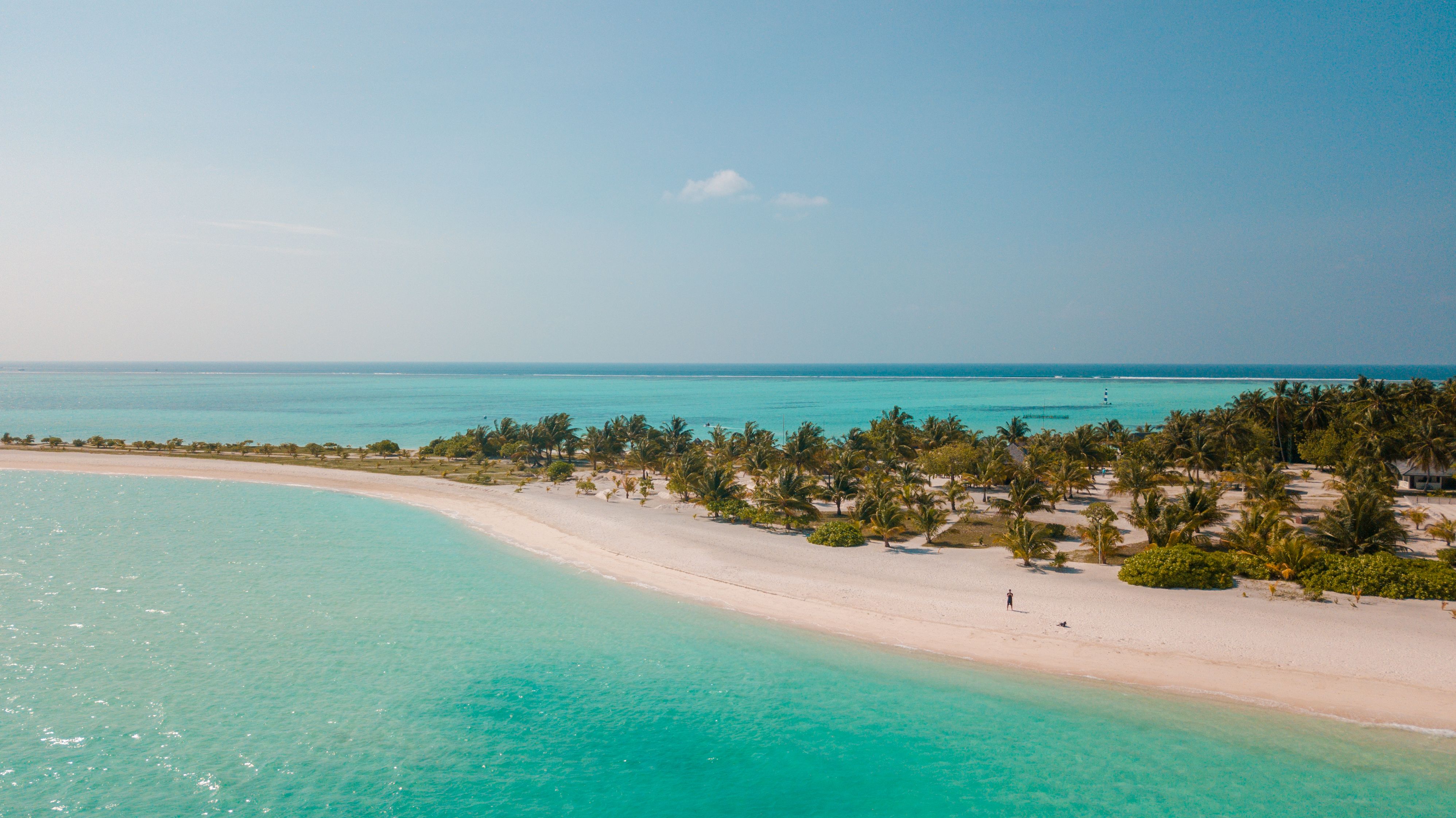 Zanzibar white sand beach with turquoise Indian Ocean water and traditional dhow sailboat